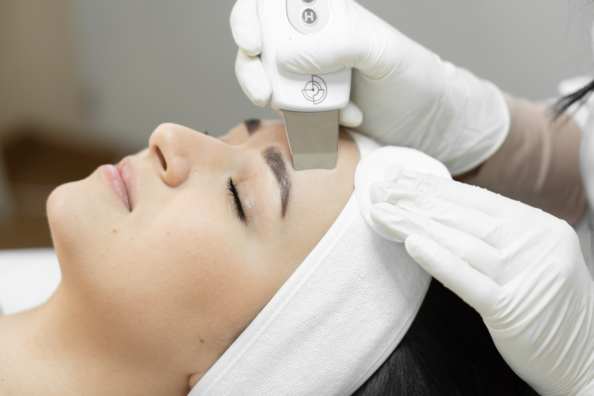 Feeling of freshness and rejuvenation: ultrasonic facial cleansing from a professional cosmetologist to care for skin health. Relaxation and relaxation in beauty salon. Woman enjoying procedure in spa