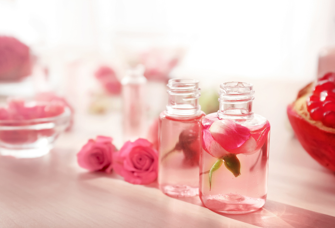 Beautiful Composition with Perfume Bottles and Roses on Table